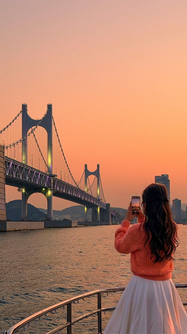 광안대교를 바라보며 노을 사진을 찍는 손님